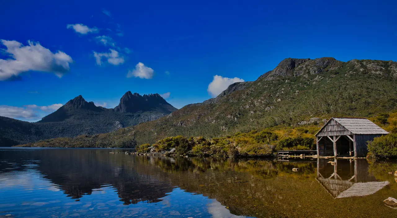 Cradle Mountain reflected in Dove Lake beside the old timber boatshed